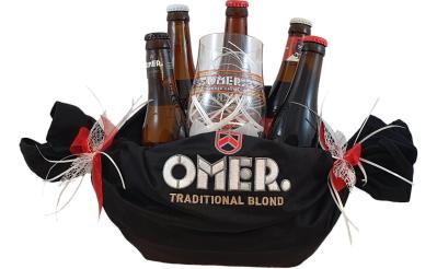 Keukenschort van Omer gewikkeld rond een bakje gevuld met o.a. bier en glas van Omer